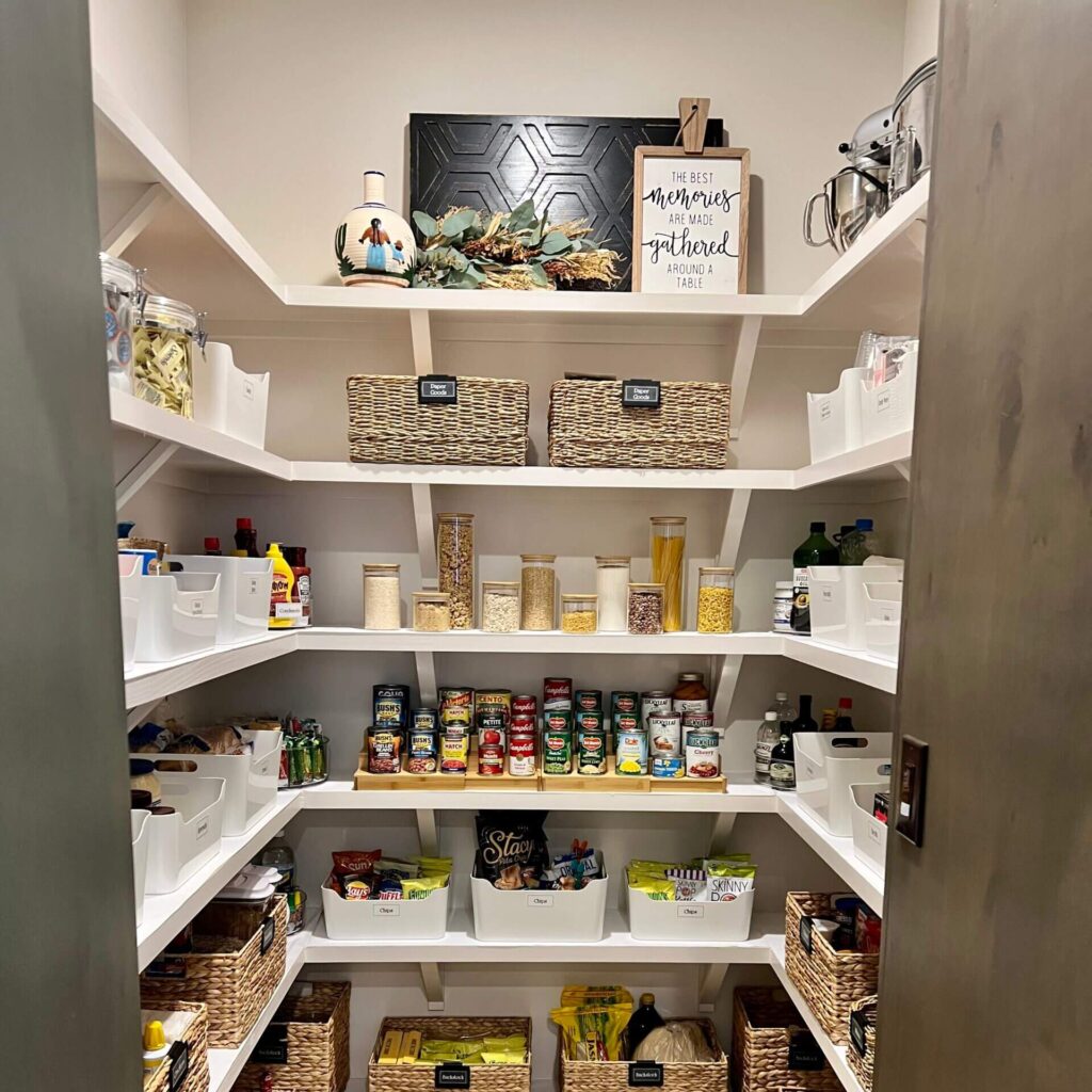 A well-stocked pantry with white shelves neatly organized